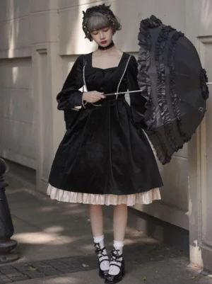 Full front pose of black velvet lolita jumper dress with cascading ruffled skirt hem and long puff sleeves, model holding decorative black parasol
