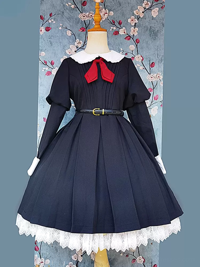 Full front view of classic long-sleeve black lolita dress with structured pleated bodice, white lace trim, red bow accent, and gold buckle waist belt on dress form
