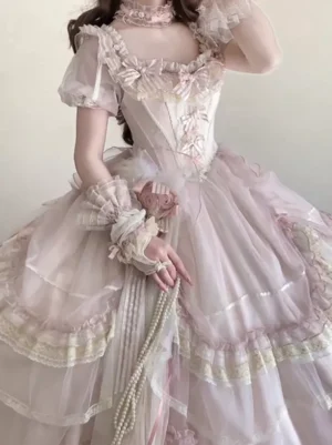 Classic lolita dress close-up mid-body detail showing off-shoulder square neckline with bow embellishment ruffled wrist cuffs and pearl chain accessory refined decorative elements
