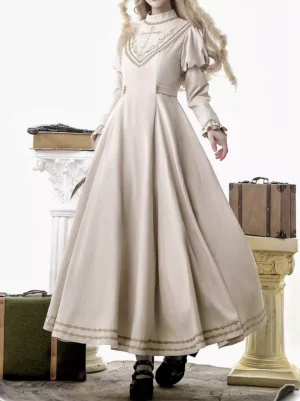 Classic lolita empire waist gold embroidery royal tea party gown shown from side rear angle on blonde model wearing vintage European styling with beige fabric and golden cross chest embroidery