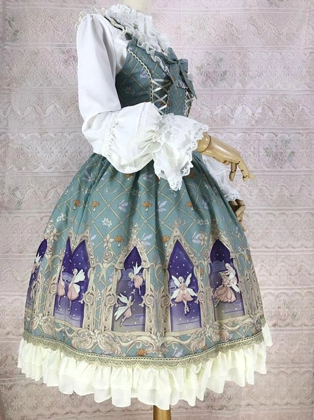 Sage green sleeveless lolita dress side three-quarter view showing flounced white blouse layered under jumper with cream ruffled skirt hem
