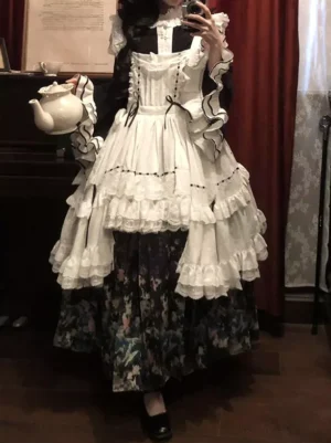Classic lolita maid outfit with tiered white ruffle apron and ruffled cuffs model holding ceramic teapot tea party styling
