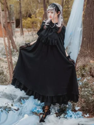Black classic lolita one-piece OP dress with stand collar and ruffled details worn by model outdoors in woodland setting showing front view with long sleeves and full skirt