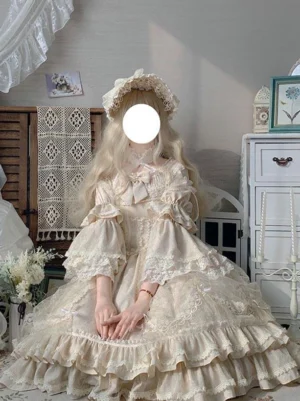 Classic beige lolita one piece dress sitting pose with lace bonnet and layered ruffled skirt vintage aesthetic