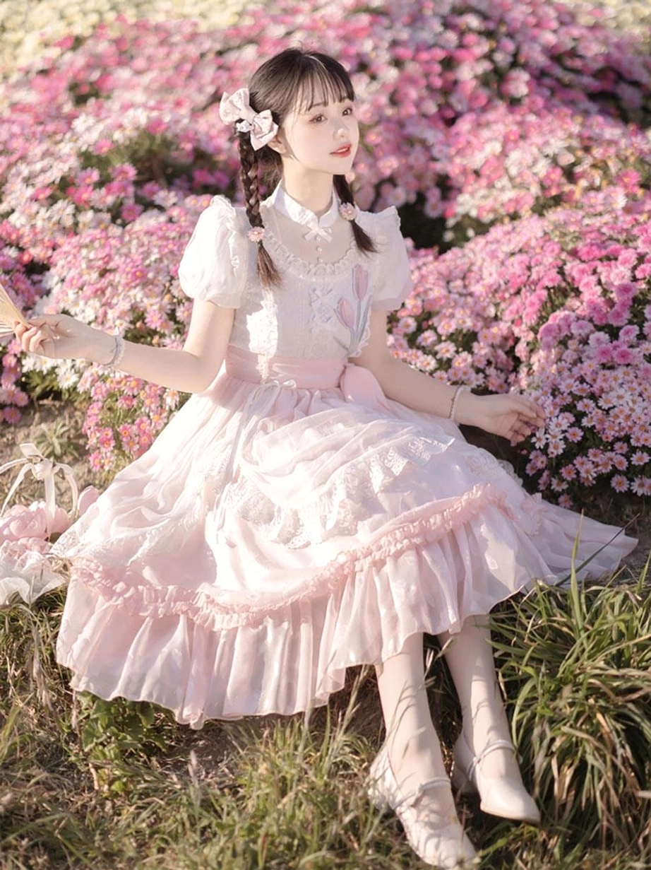 Pink classical lolita dress front three-quarter sitting pose lace decorations layered ruffled skirt flower field