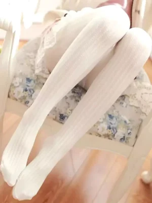Classic lolita pinstripe velvet pantyhose in off-white displayed on legs with floral indoor setting, showing vertical ribbed texture and full-foot coverage design