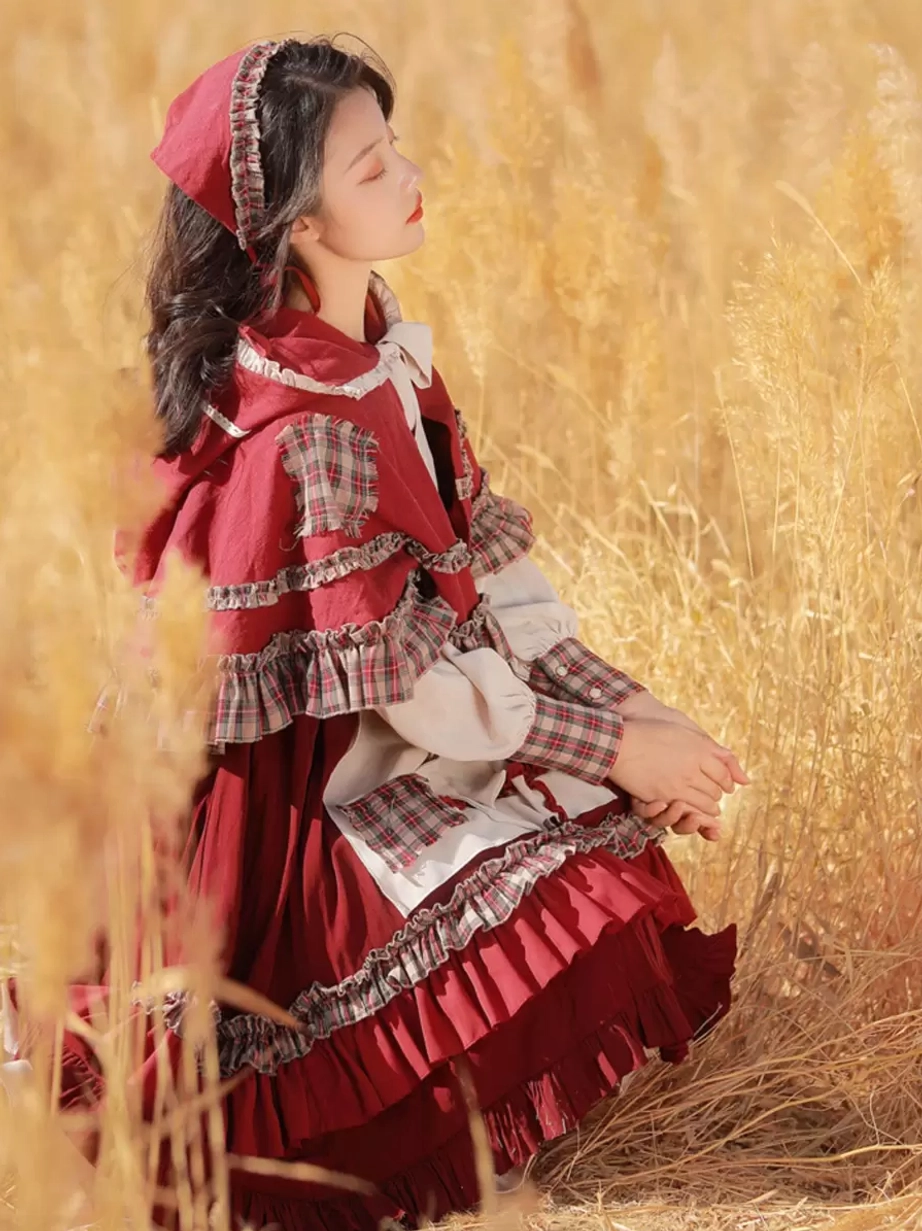Classic lolita red riding hood dress - side profile showcase - matching head scarf and ruffled cape - patchwork front panel details in burgundy and cream - wheat field setting