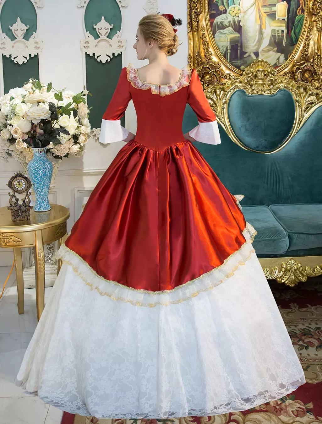 Victorian Lolita formal dress full front view with floral arrangement nearby, showcasing red satin bodice, floor-length white lace skirt, bell sleeves, and ornate Victorian silhouette details