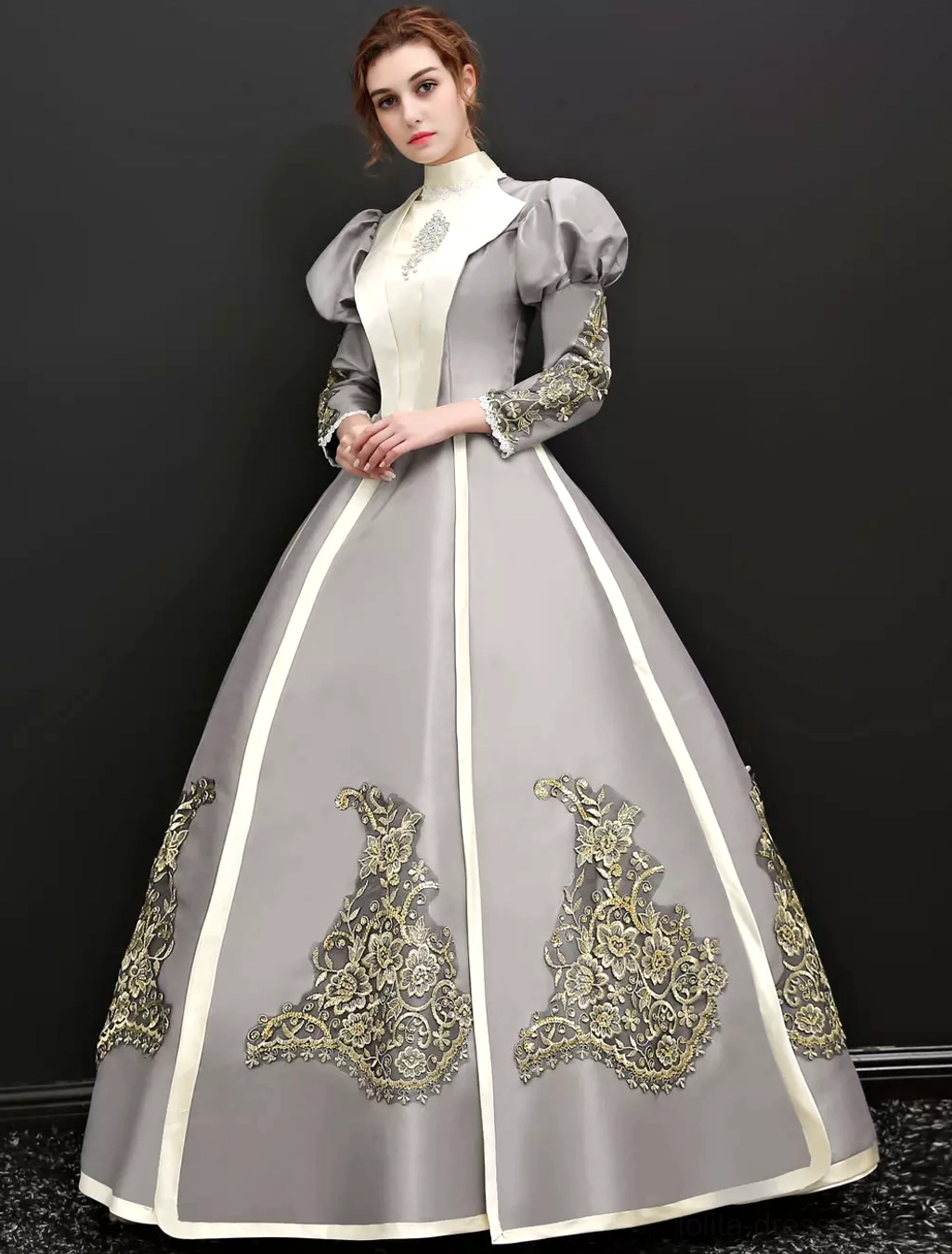 Classic Lolita Victorian dress front-side full view with hands folded, displaying stand collar, puffed sleeves, and gold floral embroidery on cream and grey design