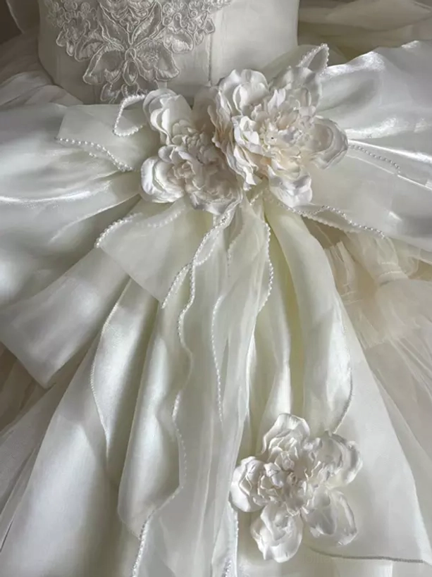 Close-up details of Classic Lolita wedding dress showing satin bow rhinestone ornament embroidered lace and 3D fabric flowers