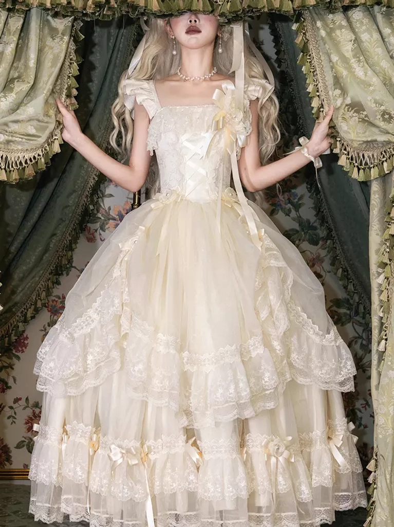 Classic Lolita white fairy wedding dress with ruffled square neckline and multi-layered lace ballgown skirt, front full-body view on model with vintage curtain backdrop