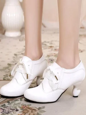 Pair of elegant white lace-up Lolita round-toe heels front flat view displaying polished PU surface and curved block heel structure on decorative floral carpet