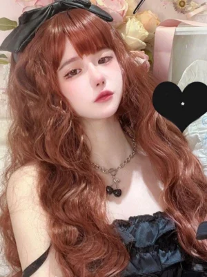 Coffee brown long curly lolita wig with air bangs worn by female lolita model in floral indoor setting, featuring loose water wave curls and black satin bow hair accessory, rococo style sweet lolita fashion