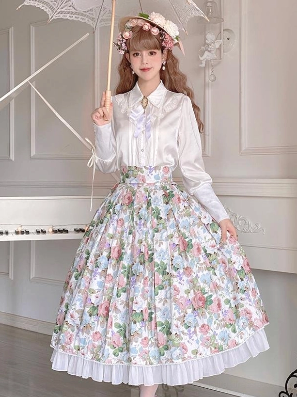White cottagecore pastoral lolita skirt floral print full-body front view with ruffled hem, modeled with long-sleeve white blouse, flower hair ornament, and lace parasol in indoor piano studio setting
