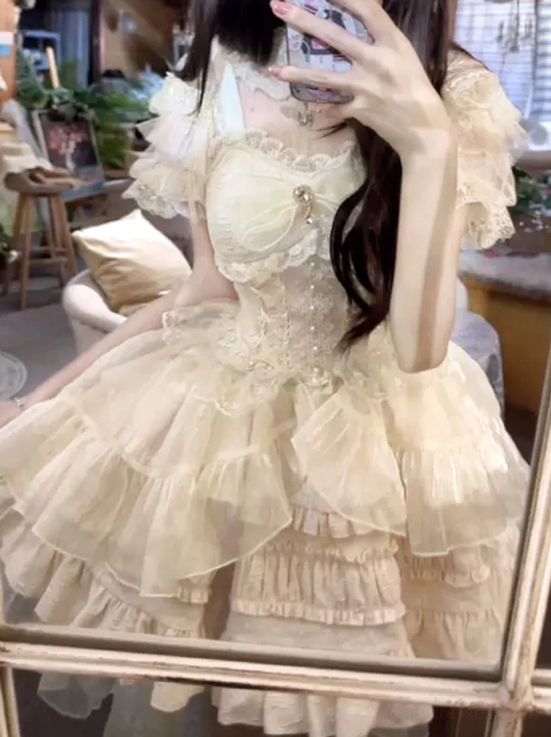 Cream yellow light apricot sweet lolita dress with off-shoulder puff sleeves multi-layer ruffled tulle skirt chest bow and lace trim mirror selfie view
