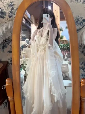 Cream fairy lolita sleeveless ruffled maxi dress full-length front view with V-neck silhouette and voluminous ruffled hem on model
