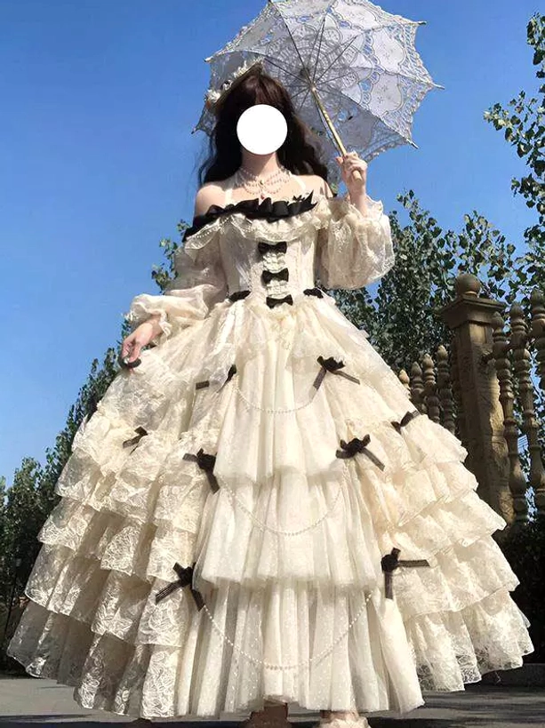 cream off-shoulder tiered lace fairy lolita wedding ball gown with black bows and long sleeves front view full body model outdoors