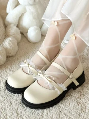 Cream colored lolita mary jane shoes with lace bow trim and heart-shaped buckle strap, front view worn on feet with sheer bow stockings