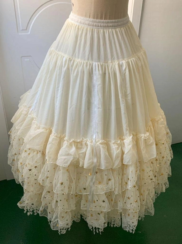 Cream-colored Lolita petticoat side-rear view showing tiered ruffled hem star print tulle and elastic waistband construction