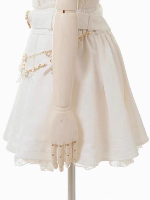 Cream white steampunk lolita skirt side close-up view featuring gold chain decorations, striped lace hem trim, ruffled layered underskirt detail