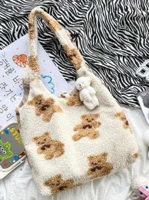 Cream fleece teddy bear tote bag with plush bear charm displayed on zebra print bedding, sweet lolita accessory flat lay