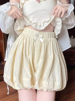 Cream yellow lolita bloomers front close-up showing elastic waist, decorative front bow, and lace hem with ruffled details
