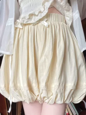 Side profile of cream yellow lolita safety shorts featuring high elastic waistband, side drawstring, and lace-trimmed leg opening