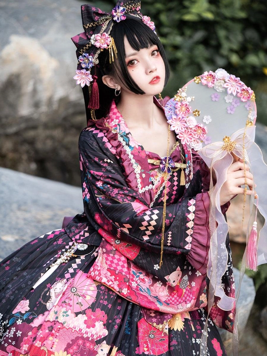 Close-up three-quarter view of dark floral lolita kimono dress with pink botanical prints and traditional bow hair ornaments