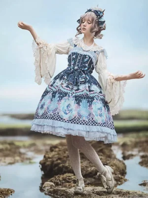 Deep blue mermaid themed classical Lolita JSK dress with ruffled layered hem and marine print on model in three-quarter front pose at seaside tidal beach