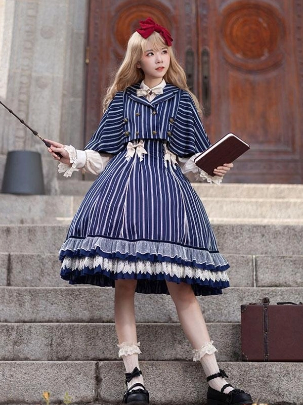 Deep blue striped lolita jumper dress worn outdoors, front full view on stairs with book and wand accessories, showing structured silhouette