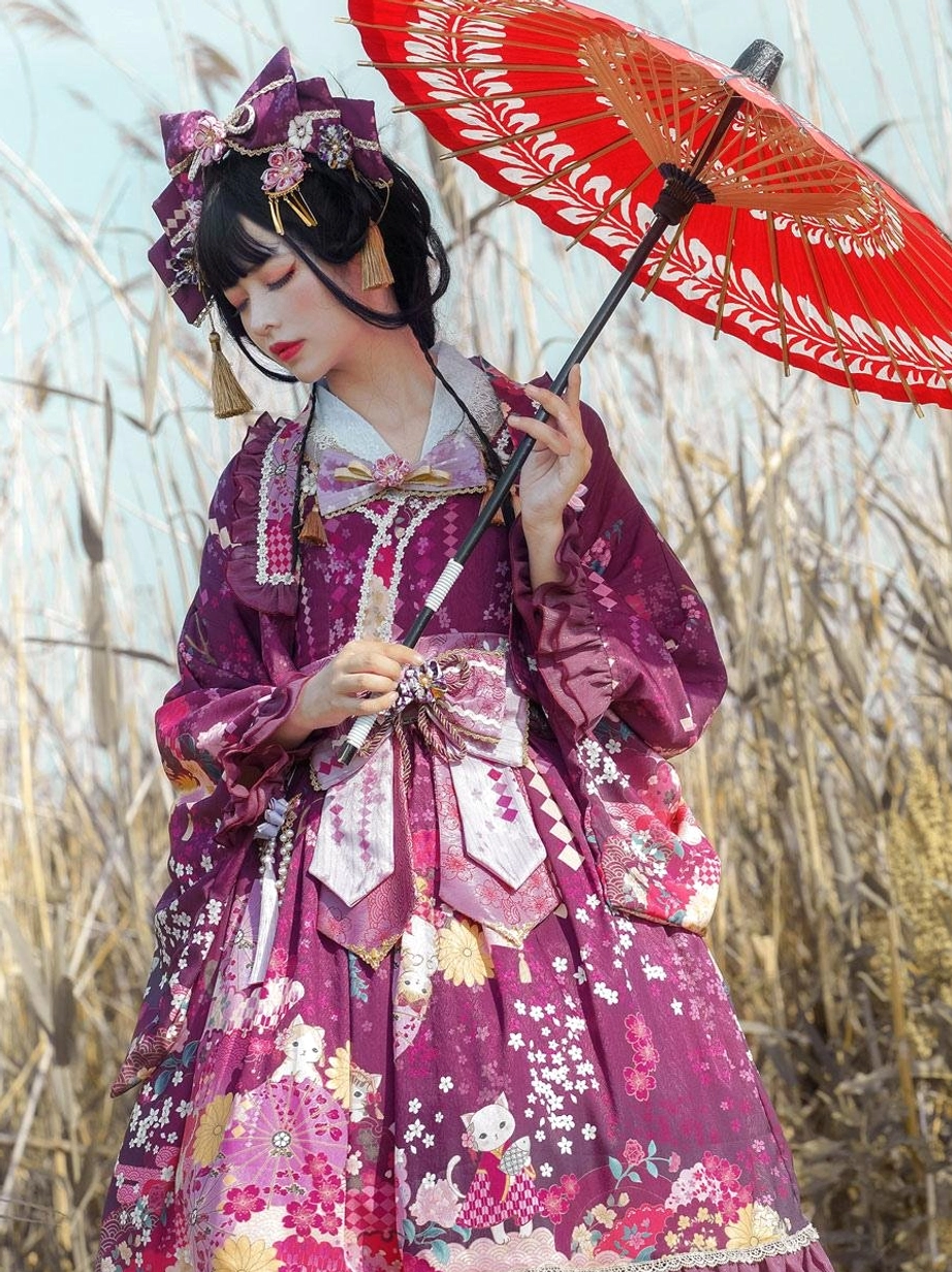 Deep purple floral lolita outfit with kimono long sleeves traditional hair ornaments and waist bow worn with red umbrella in reed field three-quarter view