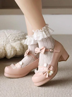 Dusty pink sweet lolita Mary Jane shoes with round block heel, pearl-adorned bow, and ankle strap displayed on woven rug background