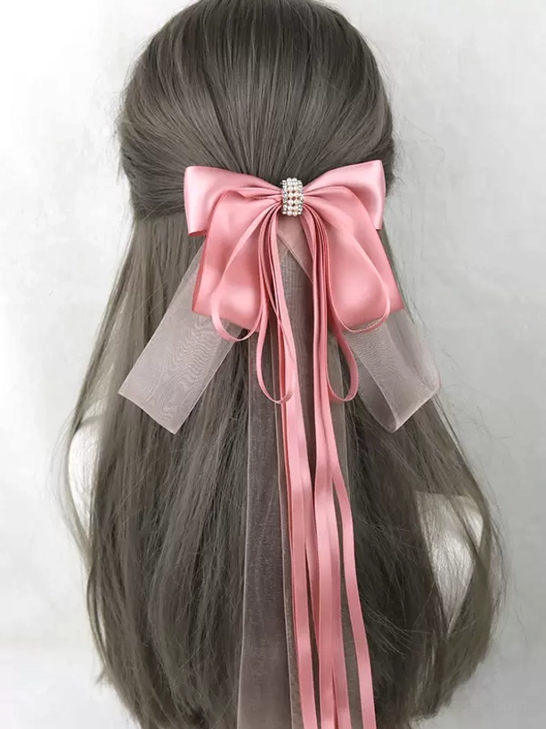 Dusty rose satin bow hair accessory with rhinestone fastener and dual-style long ribbon streamers, worn on gray-brown mannequin, lolita headdress rear display
