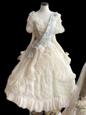 Ecru white sweet lolita wedding gown with voluminous ruffled layered skirt and puff sleeves displayed on mannequin with dusty blue sash and coordinating bow accessory, front full view