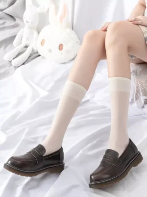 Ecru white sheer Lolita socks calf-length with wide matching cuff worn with brown penny loafers and plaid skirt
