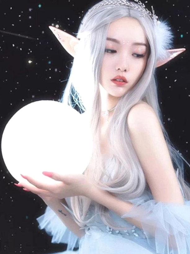 Silver grey wavy lolita wig with elf ears and feather crystal hair band worn by model, right three-quarter profile view against nighttime starry backdrop showing wig volume and wave pattern