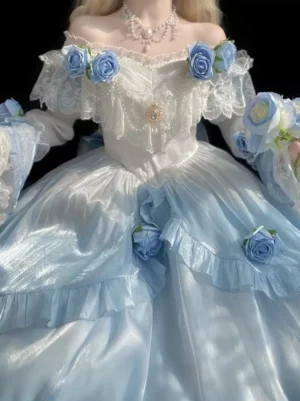Off-shoulder blue and white Sweet Lolita dress close-up showing pearl necklace, chest gem ornament, ruffled off-shoulder sleeves, and white lace trim details - upper body detail shot
