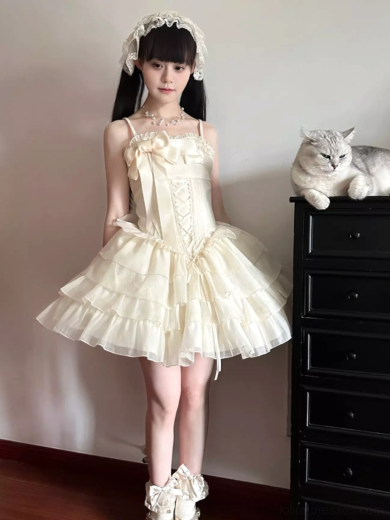 Ivory corset Lolita mini dress front full-body view with model wearing lace hair hoop accessory and tiered tulle skirt, styled in vintage indoor room with wooden dresser and cat
