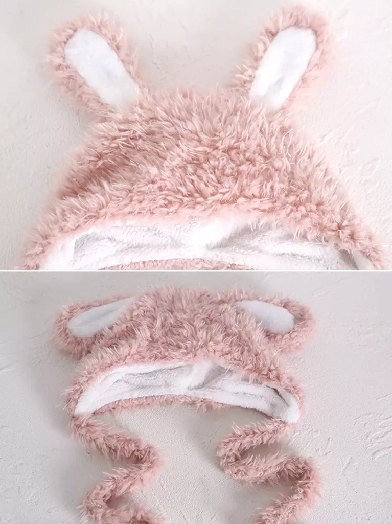 Close-up top view of pink fuzzy rabbit ears with white inner ear panels and shaggy texture