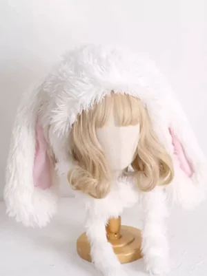 Oversized plush rabbit ear lolita headdress with fuzzy white exterior, pink inner ear details and coordinating fur neck scarf on blonde curly wig display mannequin