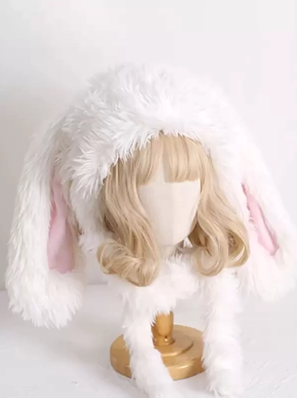 Oversized plush rabbit ear lolita headdress with fuzzy white exterior, pink inner ear details and coordinating fur neck scarf on blonde curly wig display mannequin