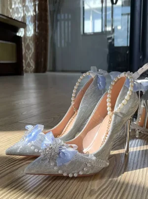 Pearl crystal glitter bridal stiletto pumps front three-quarter view with light blue tulle bow and pointed toe on wooden floor lolita wedding heels