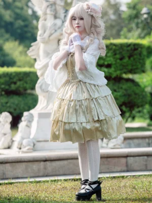 Full-body sweet lolita coordinate featuring golden sleeveless JSK dress with white knee-high socks and black platform heels, garden setting with sculpture background