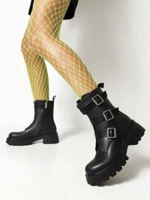 Side profile of black chunky heel combat boots highlighting adjustable metal buckles thick platform outsole and side zipper closure with fishnet tights
