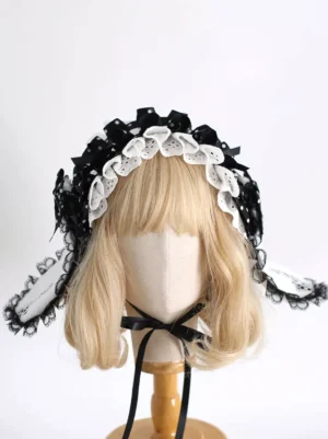 Black and white Gothic Lolita bunny ear headband with ruffled lace trim and polka dot bows, front three-quarter view on blonde wig mannequin