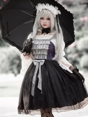 Gothic black floral lolita JSK jumper dress full front view with parasol and layered ruffles outdoor park setting