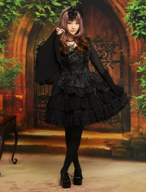Full front view of gothic black lolita dress on model wearing black tights and platform loafers, displaying dramatic flare sleeves and multi-tier ruffled lace skirt