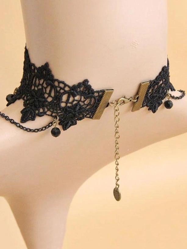 gothic choker backside view on fabric mannequin displaying black hollow lace with metal clasp and extended tail chain with black bead accents