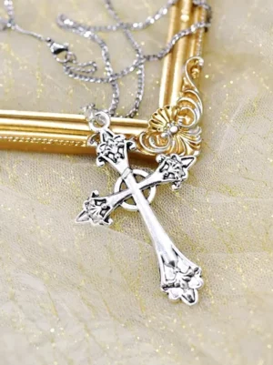 Intricate carved silver cross necklace with tangled delicate chain photographed on vintage gold frame corner with shimmering gold glitter tulle background, steampunk gothic style jewelry