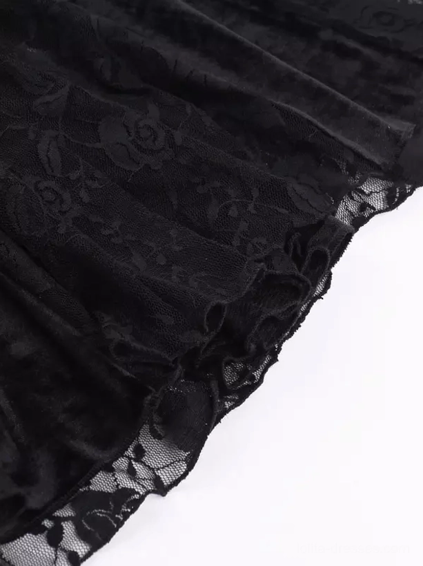 Flat lay close-up of gothic dress skirt hem showing velvet fabric with subtle floral print and delicate lace trim border detail